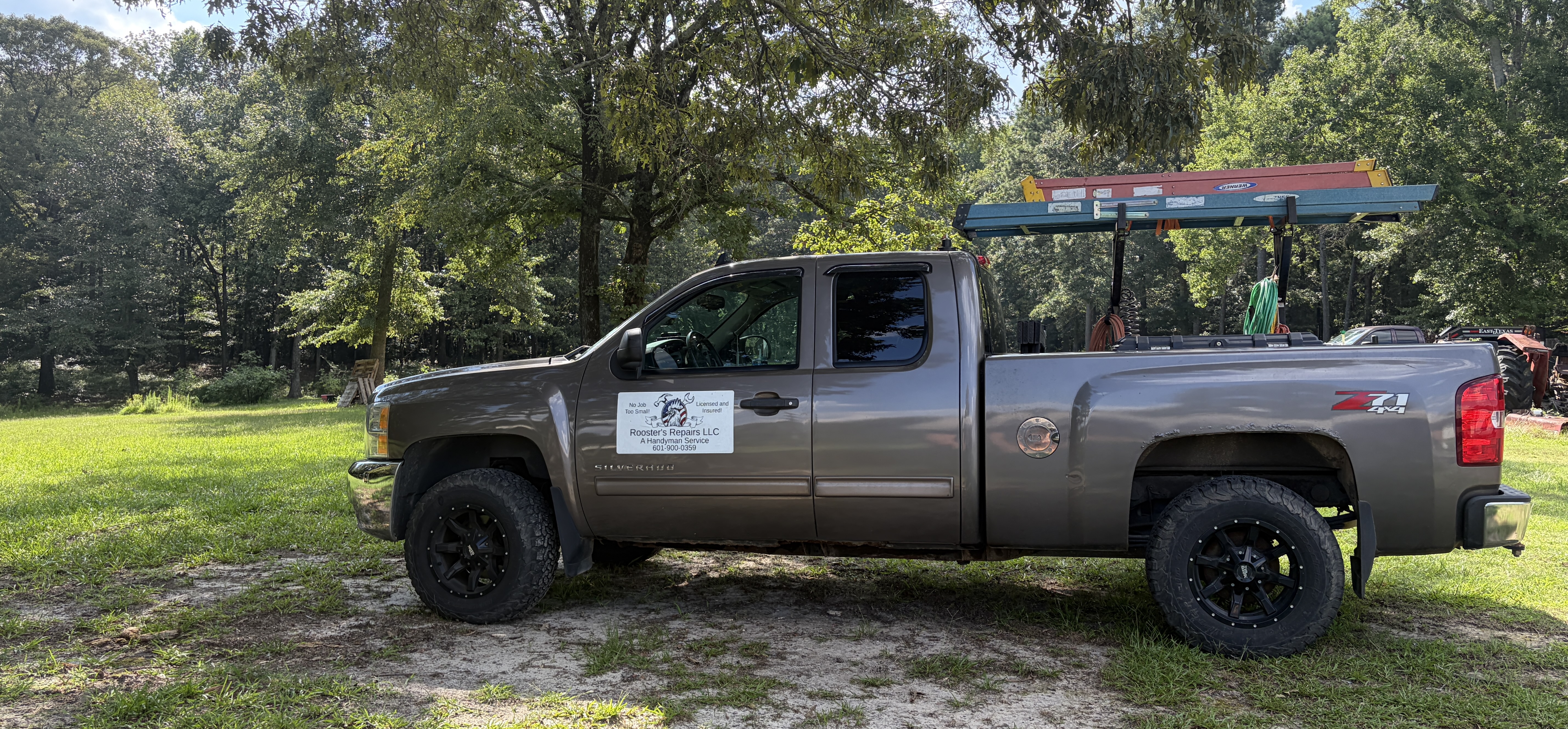 The Rooster's Repairs LLC work truck, lettered and loaded with tools, parked at a job site